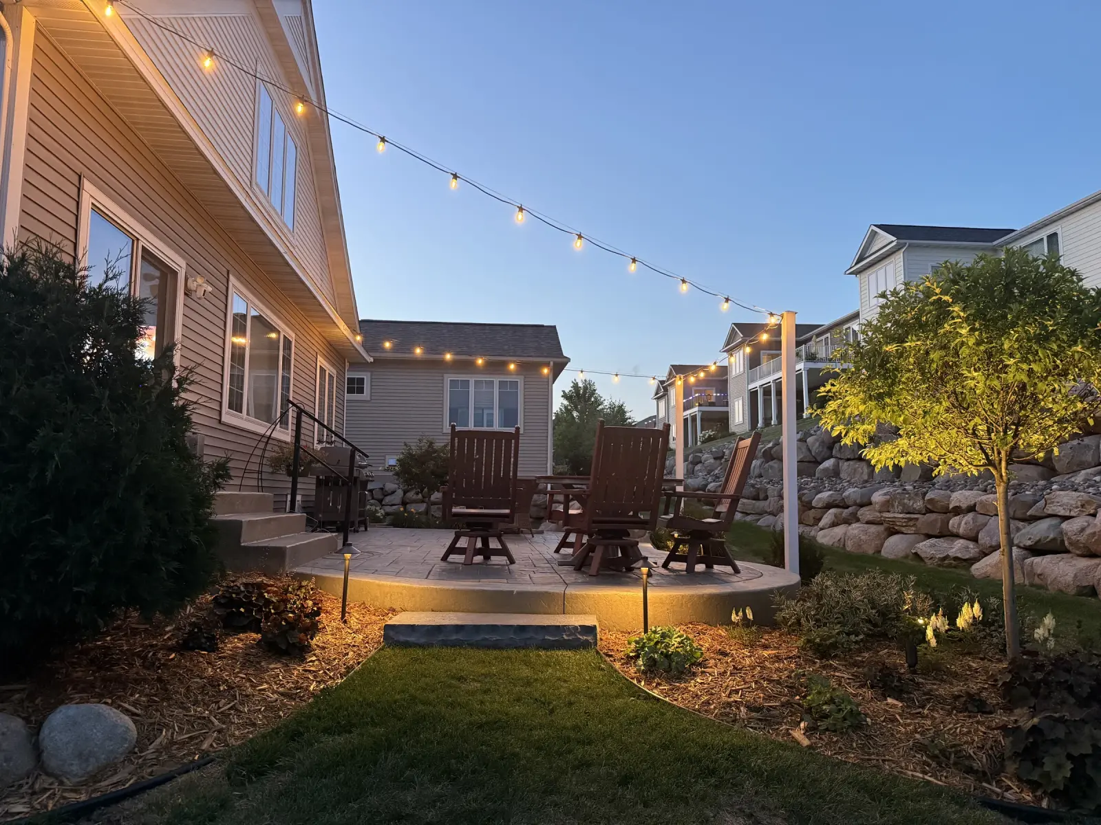 Warm bistro lights over a backyard patio